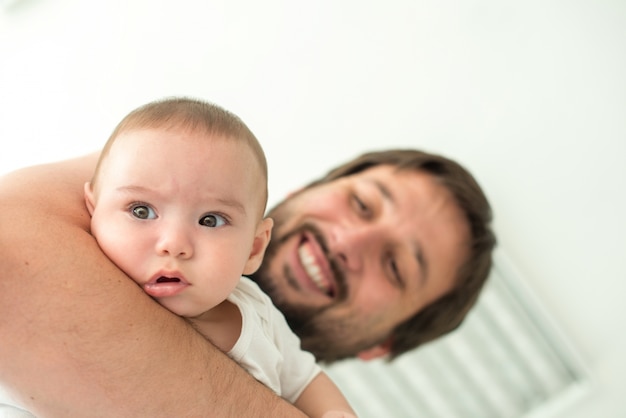 Foto padre sosteniendo a su bebé