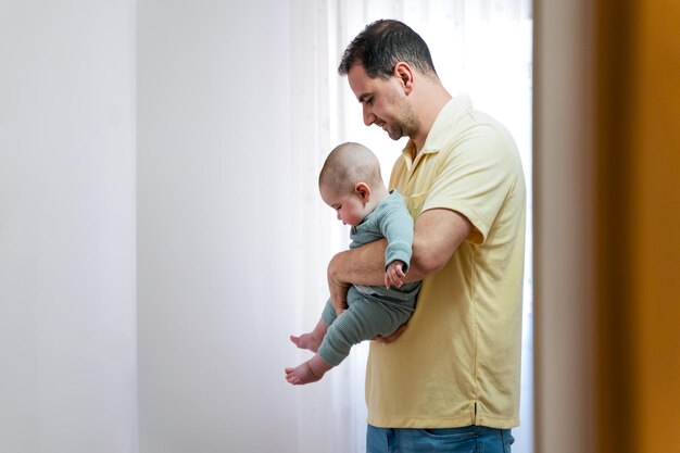 Foto un padre sosteniendo a su bebe