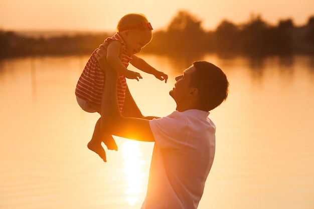 Padre sosteniendo a su hija en el aire