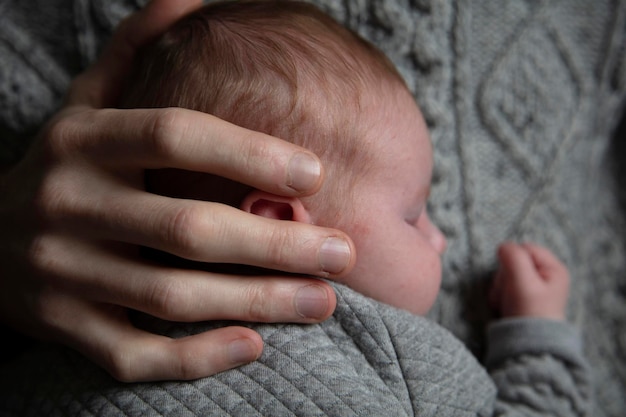 Un padre sosteniendo a su hijo pequeño en su pecho Vinculación familiar Paternidad