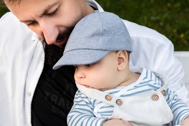 padre sosteniendo a su hijo en sus brazos sobre un fondo de vegetación