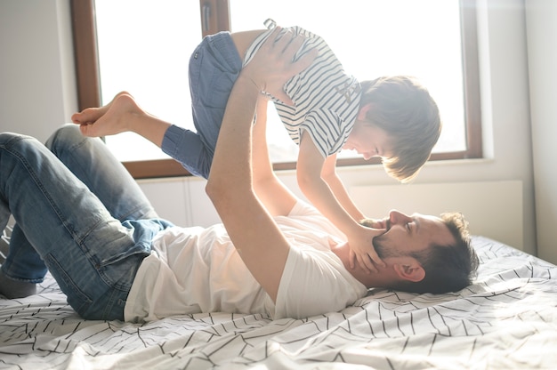 Foto padre sosteniendo a su hijo