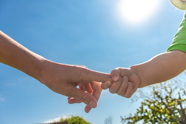 Un padre sostiene la mano de un niño pequeño el niño sostiene la mano de su madre el día del niño