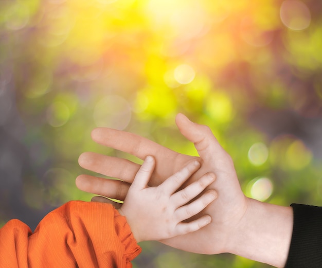 El padre sostiene la mano de un niño pequeño.