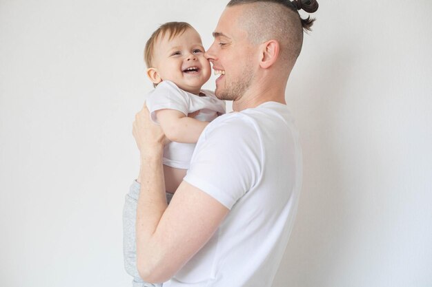 Foto padre sostiene a su hijo en sus brazos