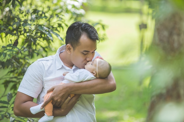 Padre con su bebé recién nacido en el parque.