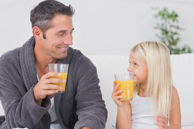 Padre y su hija vaso de jugo de naranja