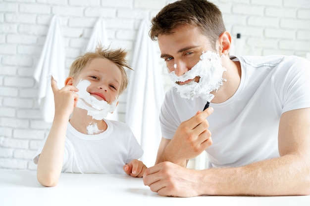 Padre y su pequeño hijo afeitándose juntos