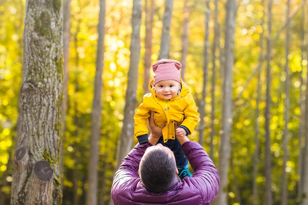 Padre y su pequeño hijo divirtiéndose en el parque otoño