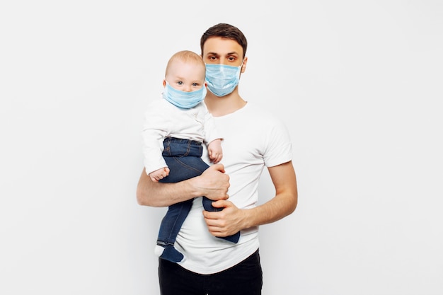 Padre y su pequeño hijo usan mascarillas quirúrgicas para protegerse contra enfermedades virales, protección contra coronavirus durante la cuarentena