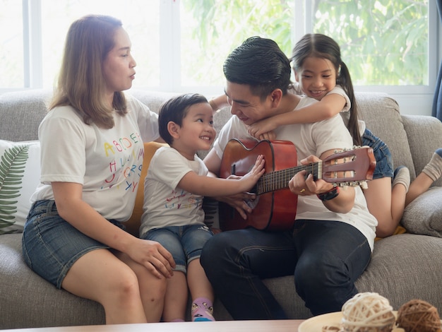 Padre tocando la guitarra para la familia