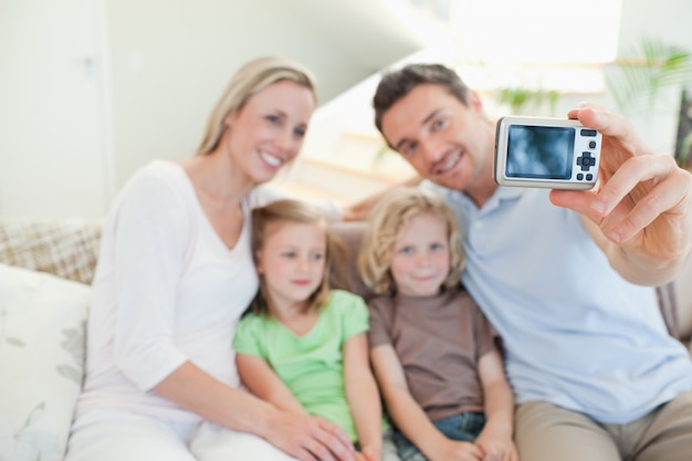 Padre tomando foto de familia en el sofá