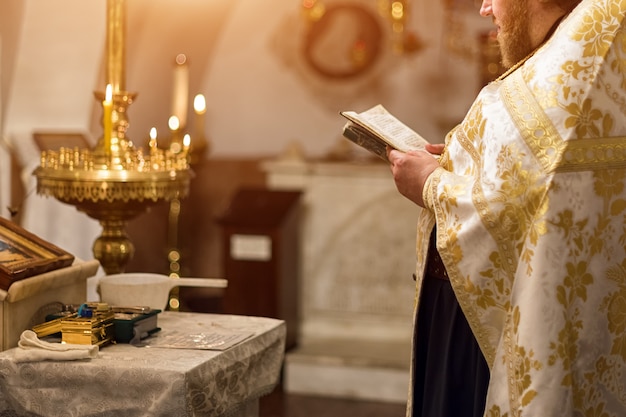 Foto padre vestindo manto de ouro na cerimônia na igreja catedral cristã, evento sacramental sagrado.