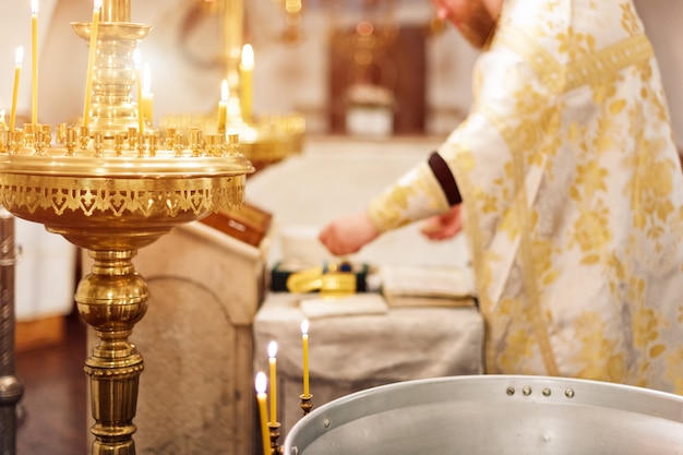 Padre vestindo manto de ouro na cerimônia na igreja catedral cristã, evento sacramental sagrado.