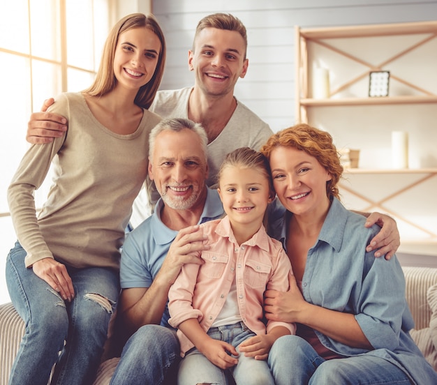 Los padres y abuelos se abrazan, mirando a la cámara.