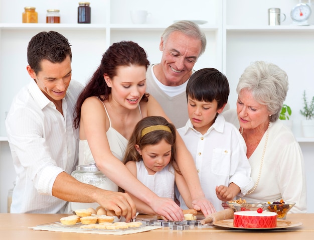Padres, abuelos y niños horneándose en la cocina
