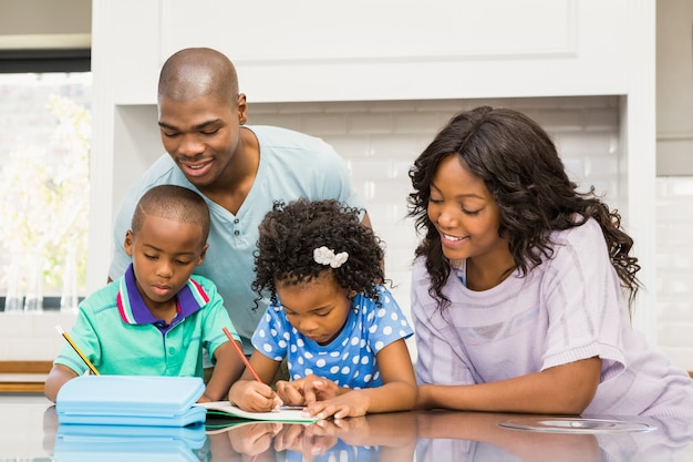 Padres ayudando a los niños a hacer la tarea en la cocina