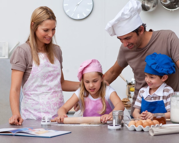 Padres ayudando a los niños a hornear en la cocina