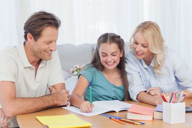 Padres ayudando a su hija a hacer su tarea