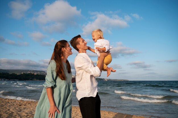 Padres con un bebé en la playa al atardecer