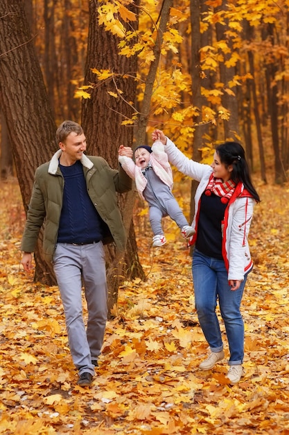 Los padres caminan y juegan con la hija pequeña.