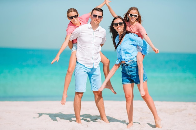 Padres cargando a sus hijas en la playa