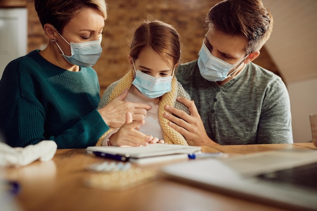 Padres cariñosos preocupados por su hija enferma durante la pandemia del coronavirus