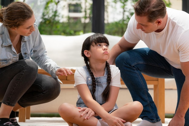 Los padres consolan a su hija con un abrazo amoroso ayudándola a sentirse segura y protegida del miedo, apoyan su cabeza en el hombro y la tristeza se desvanece Amor familiar y concepto de cuidado infantil Synchronos