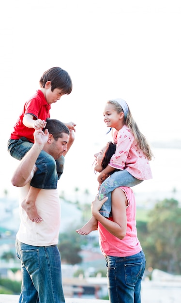 Padres dando a sus hijos a cuestas.