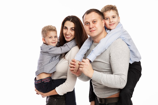 Los padres con dos hijos se abrazan y sonríen. Una familia feliz. Amor y ternura.