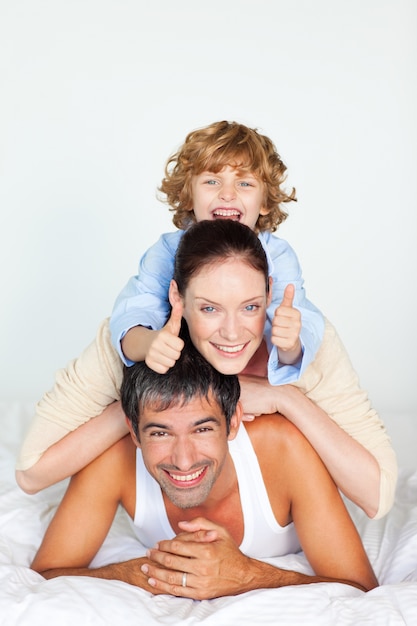 Padres e hijo jugando en la cama