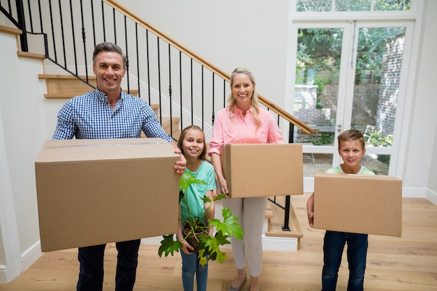 Foto padres e hijos con cajas de cartón en la sala de estar en casa