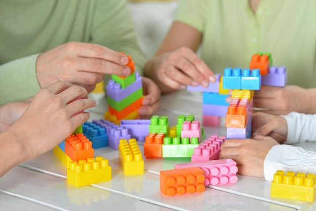 Padres e hijos jugando con coloridos bloques de plástico.