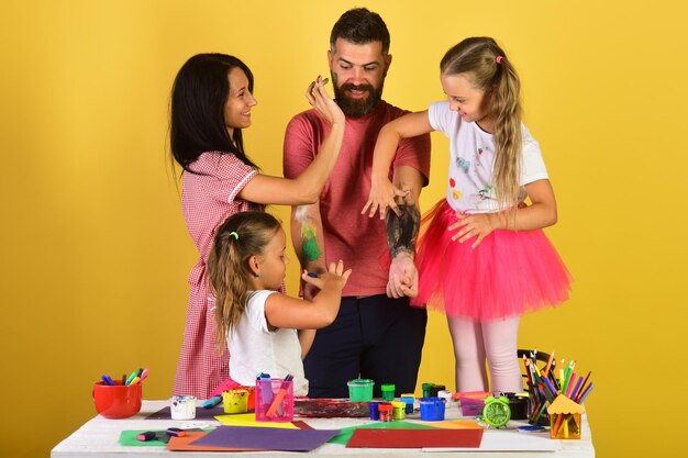 Padres e hijos pintan en los brazos de los padres con gouache