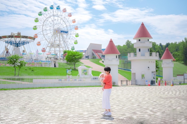 Padres e hijos sonrientes y la apariencia del parque de atracciones.