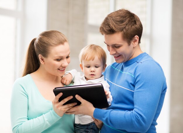 padres felices y adorable bebé con tablet pc