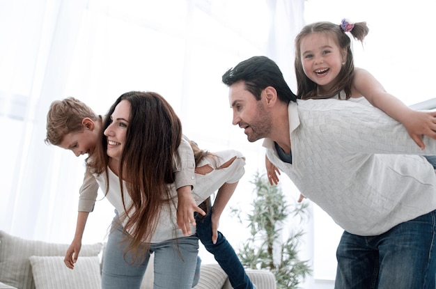 Padres felices juegan con niños en casa foto con espacio de copia