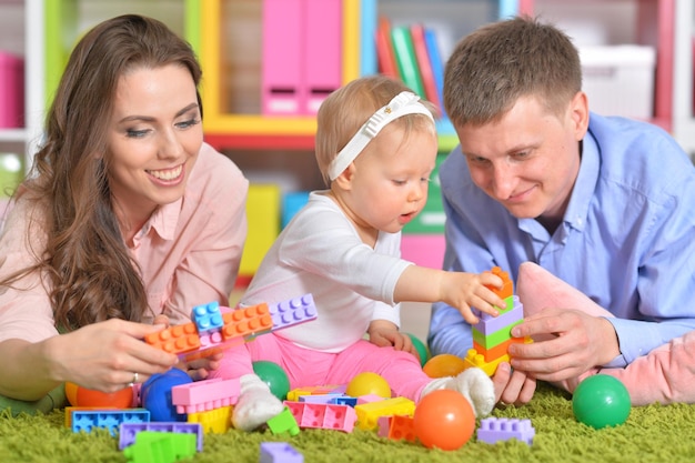 Padres felices jugando con su pequeña hija