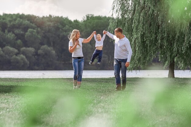 Padres felices con su pequeño hijo caminando juntos en Spring Park. el concepto de felicidad familiar