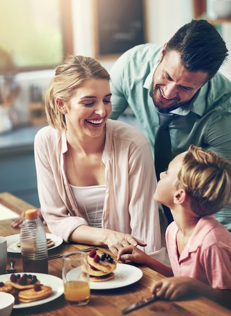 Padres y hijos en casa con el desayuno amor y felicidad en la cocina unión juntos y panqueques familia madre y padre con el niño comida saludable y comida con nutrición bienestar o cuidado en la casa