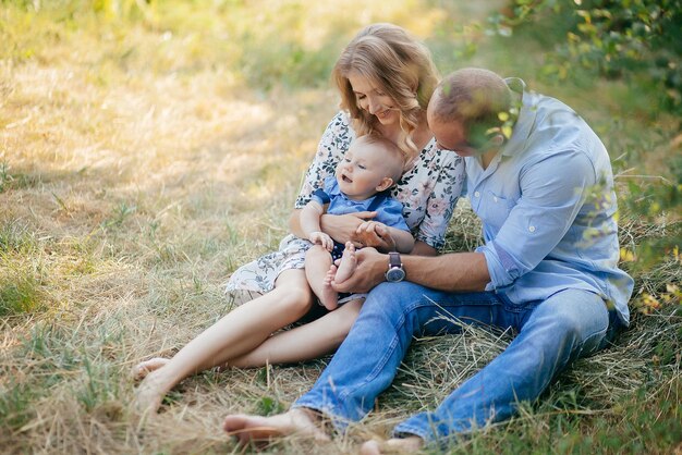 Padres jóvenes con un hijo pequeño en el parque de verano