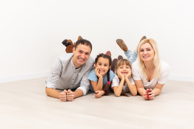 Los padres jóvenes sonrientes y sus hijos están muy felices, están en casa.