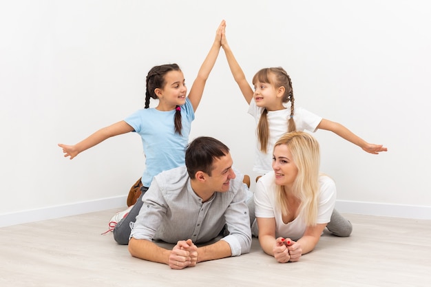 Los padres jóvenes sonrientes y sus hijos están muy felices, están en casa.