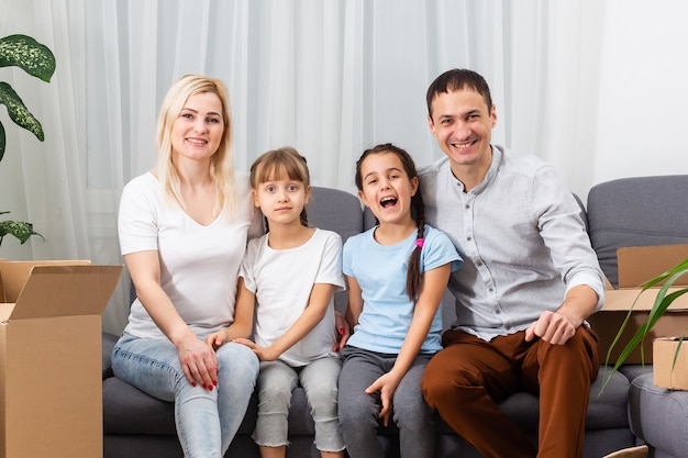 Los padres jóvenes sonrientes y sus hijos están muy felices, están en casa.