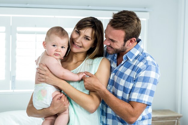 Padres con lindo hijo en el dormitorio