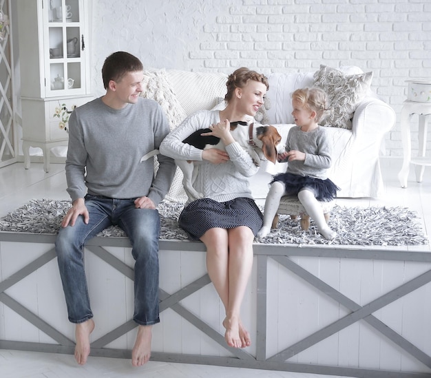 Foto padres y niña jugando con un perro