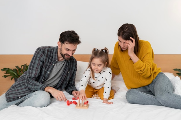 Foto los padres y el niño de tiro medio en la cama