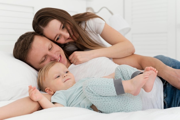 Foto los padres y el niño de tiro medio en la cama