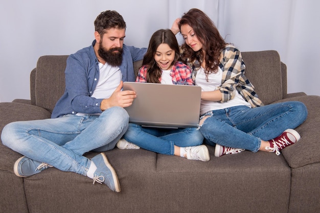 Padres con niños asombrados usan pc en las compras en casa