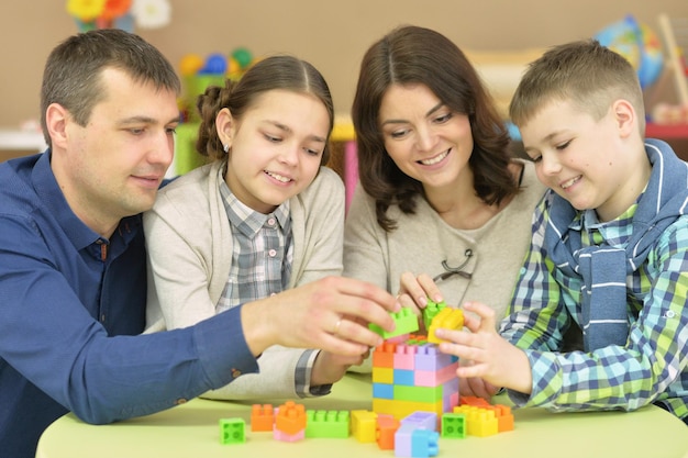 Padres con niños recogiendo bloques de plástico.